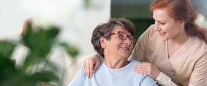 Friendly caregiver with a senior in an assisted living community