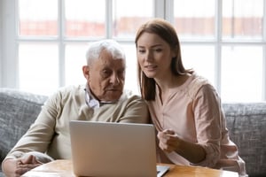 Elderly man and young women looking at computer 