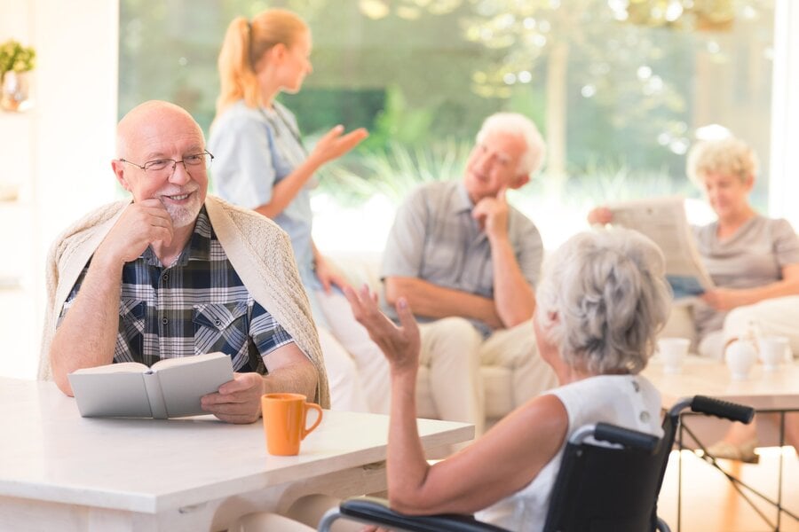 An elderly couple in a NE Ohio assisted living community talk while sitting at a table