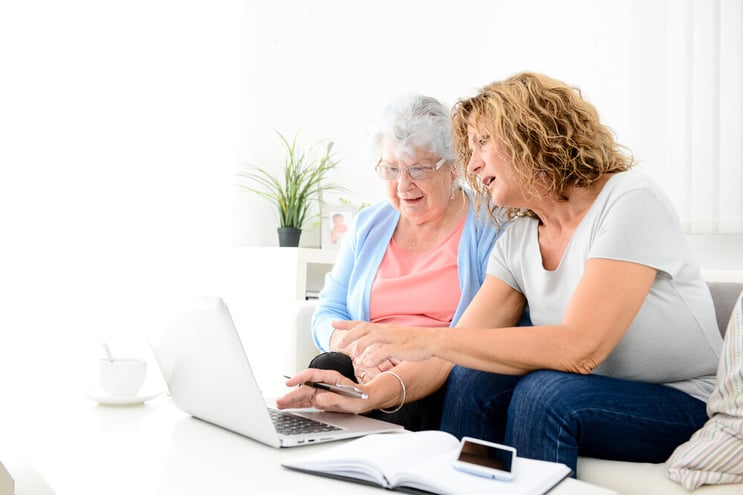 Daughter helping her senior mother on a laptop