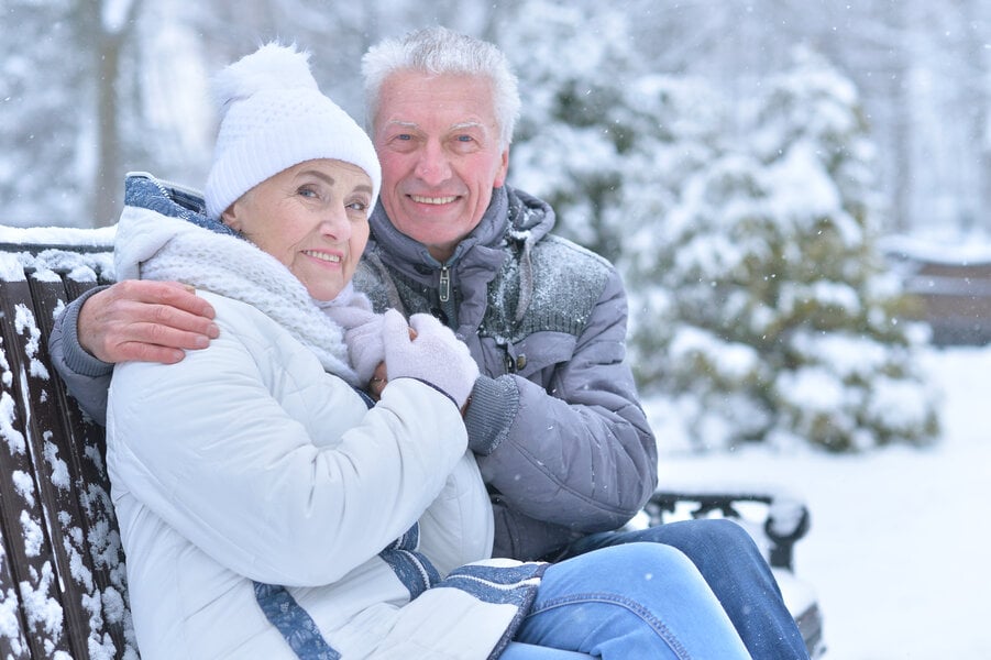 Elderly couple on park bench in the winter