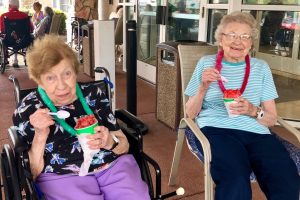 Two female seniors enjoying shaved ice outside