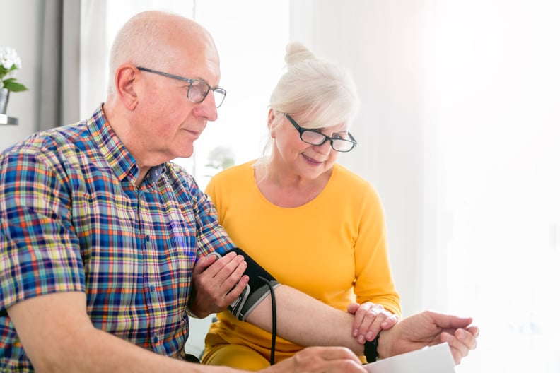 Senior-aged wife checks the blood pressure of her senior husband