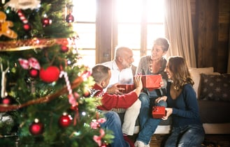 Elderly parents exchanging Christmas presents with their adult kids