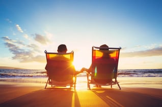 Couples sitting in beach chairs enjoying the sunset