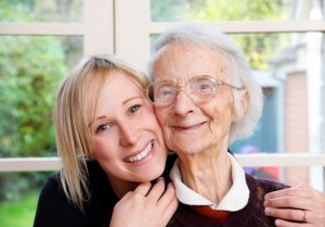 a young happy woman huggs an older happy elderly women