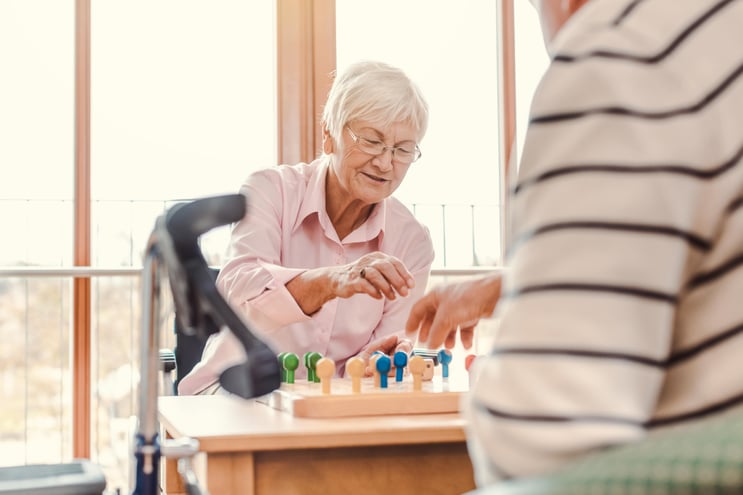 Two seniors playing a board game together