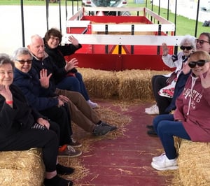 Group of seniors waving and sitting on a hayride