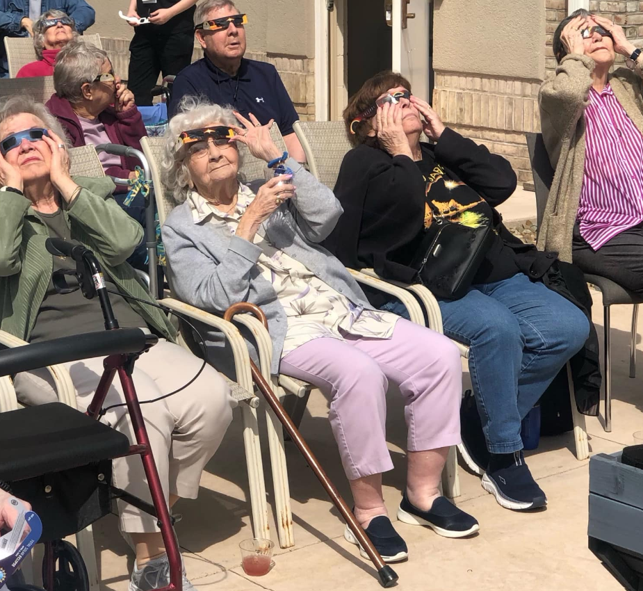 three seniors with solar eclipse glasses watching the eclipse