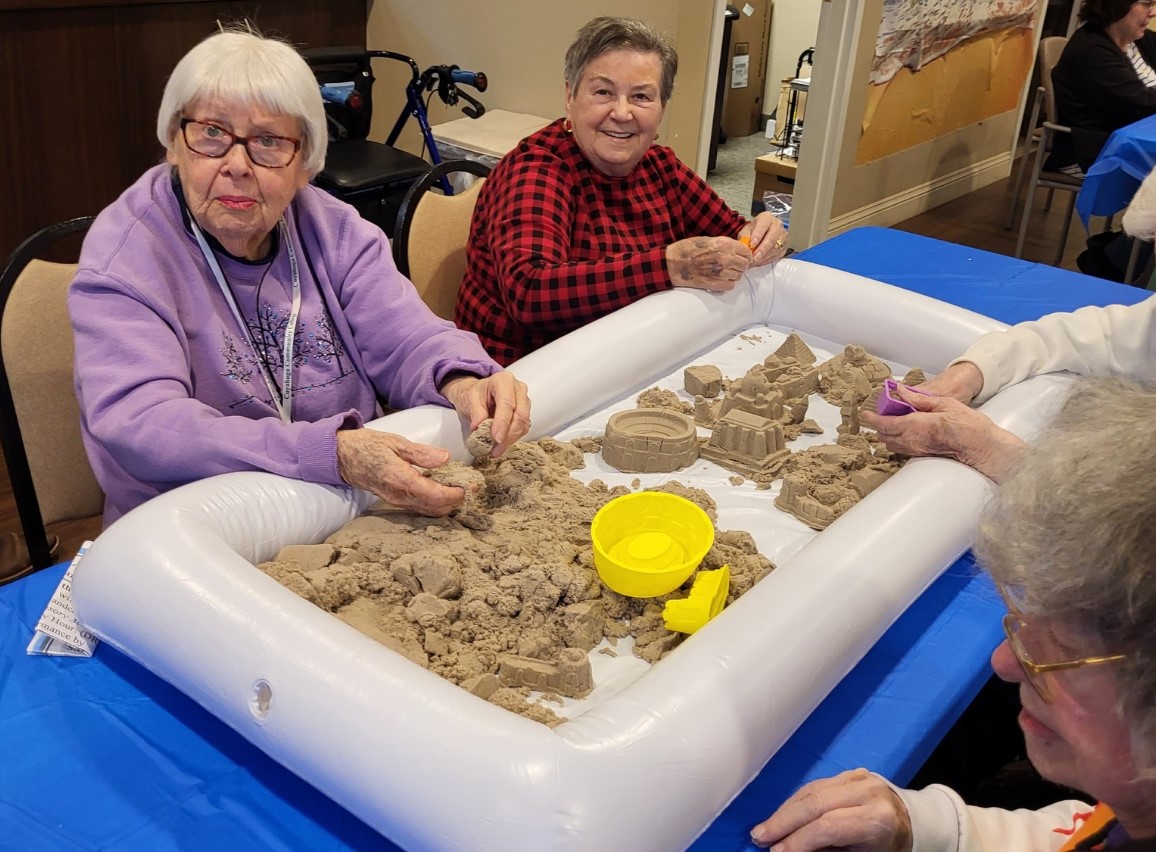 Two senior women making a sand castle