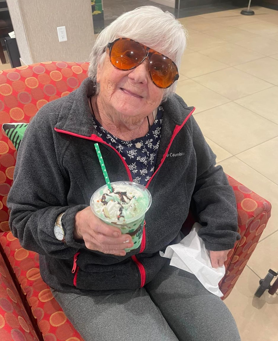 woman holding green milkshake