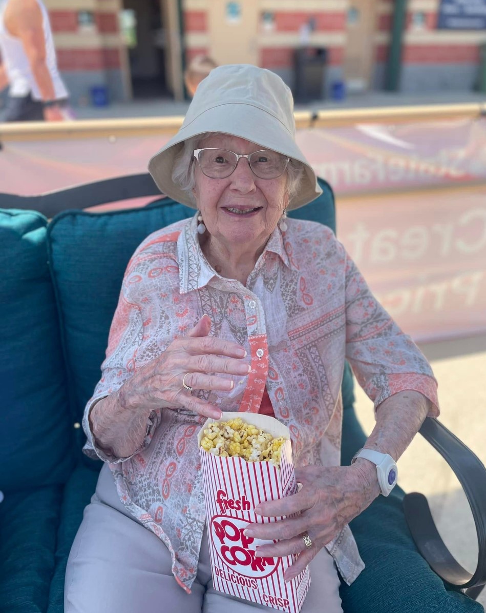 woman in hat eating fresh popcorn